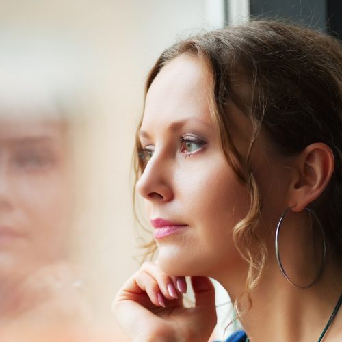 Beautiful woman looking through a window.